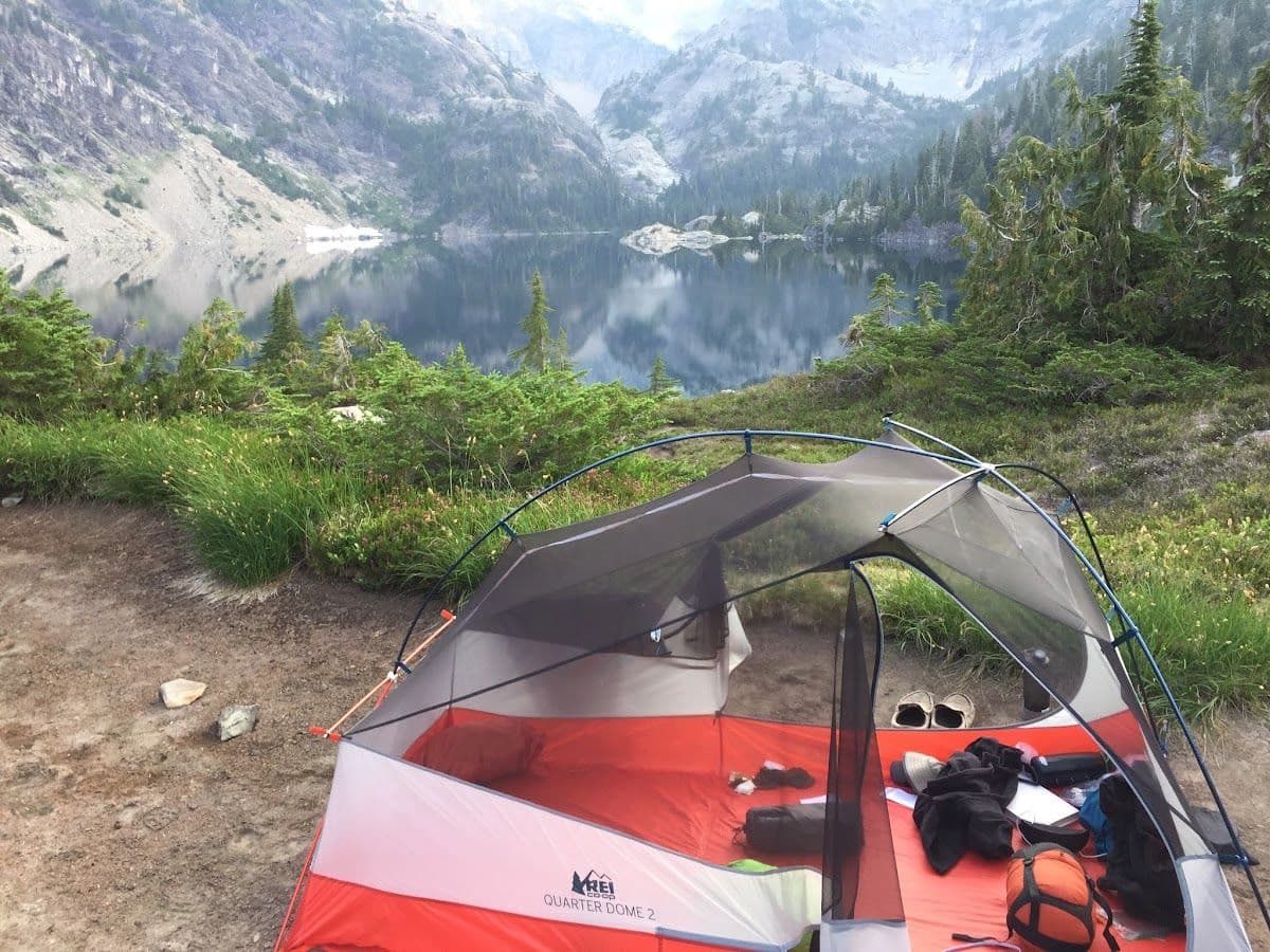 Backcountry tent beneath mountain peaks