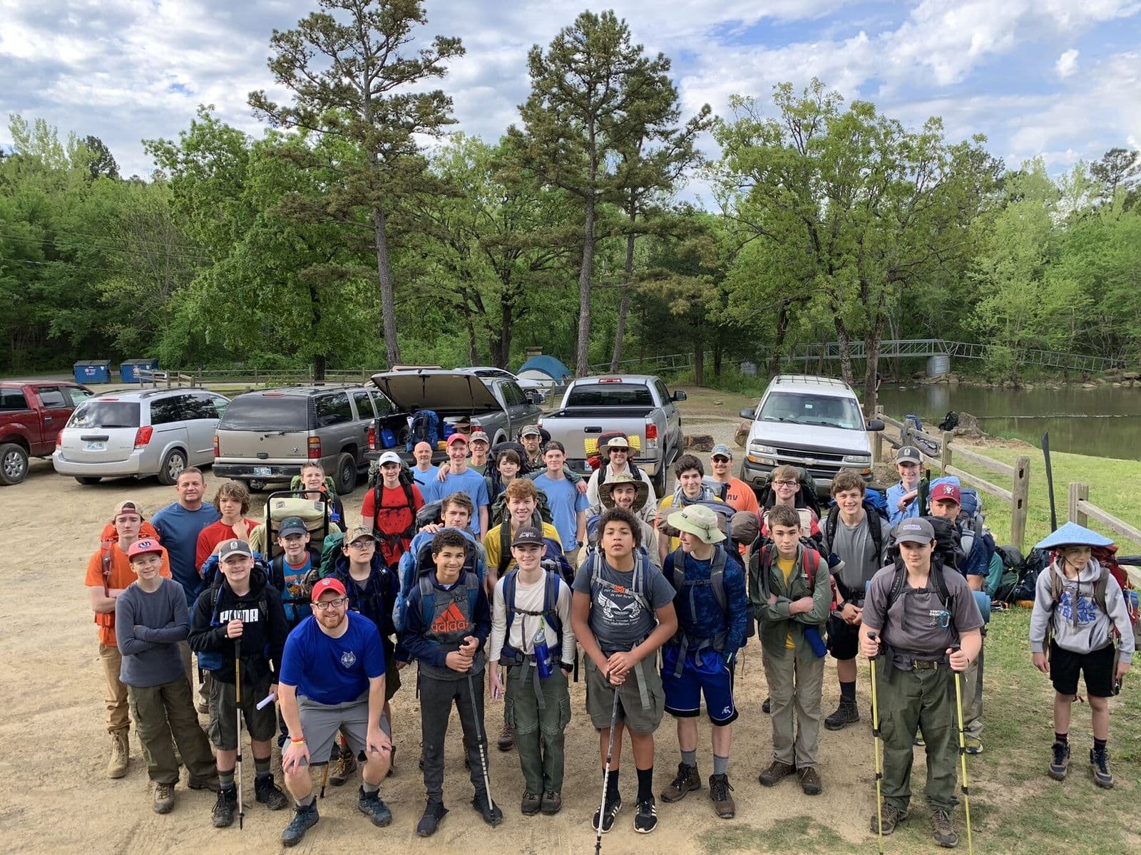 Backpacking crew gathered at a wooded trailhead